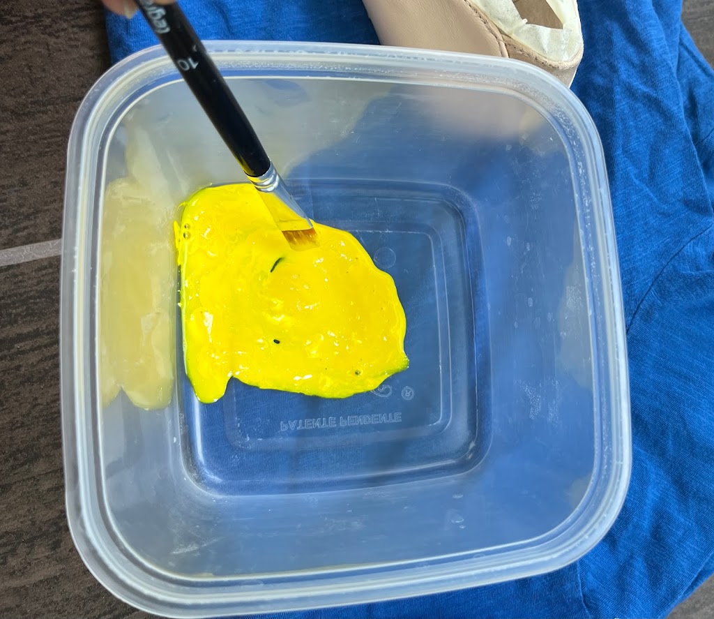 Yellow paint in a plastic tub.