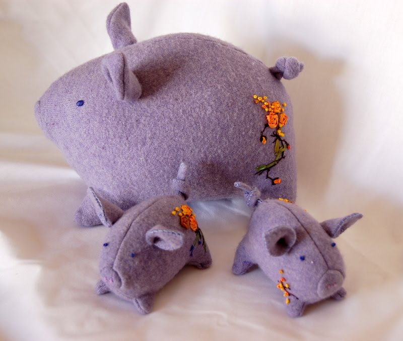 Oinkers, Doink and Sidney - three stuffed pigs made of purple wool. One is large and two are small.