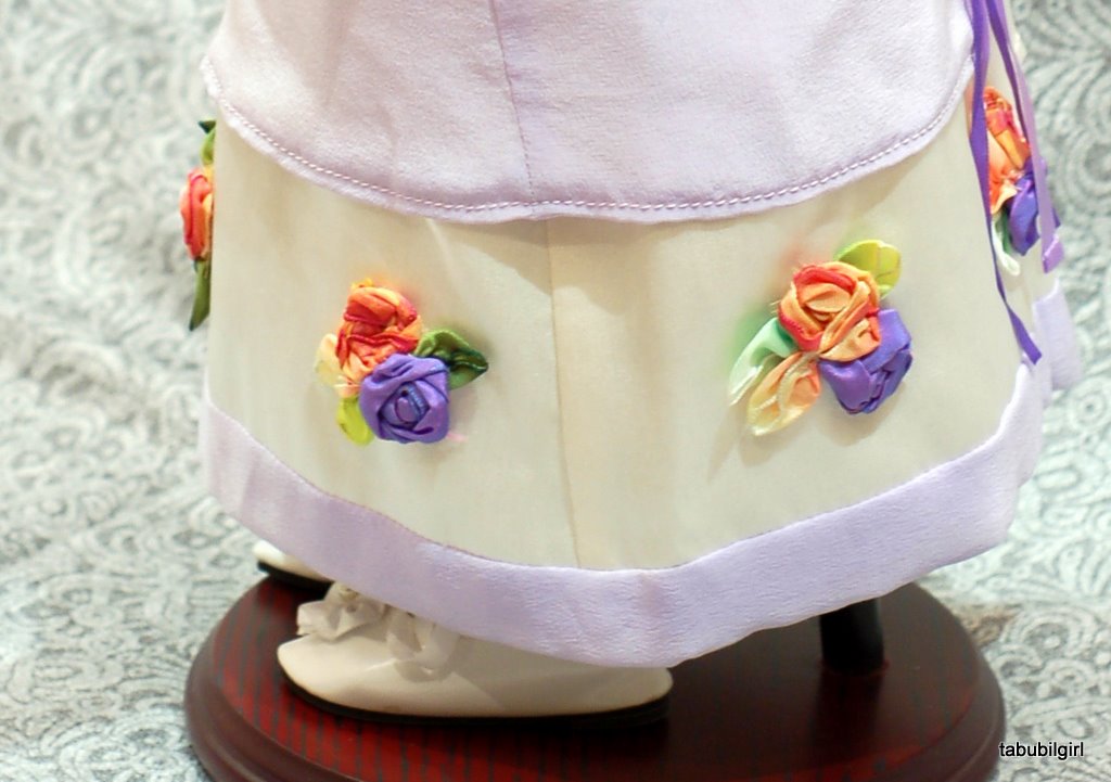 Close-up view of wired ribbon flowers on the skirt of an american girl doll regency ballgown