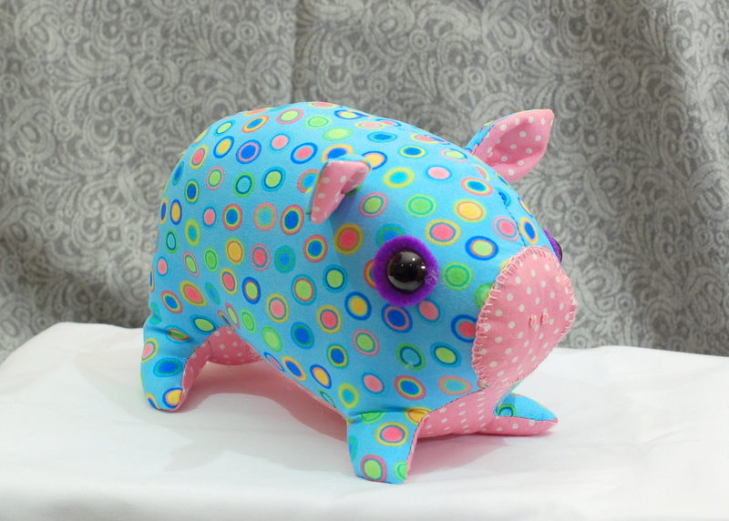 A stuffed pig softee sewn from blue polkadot fabric
