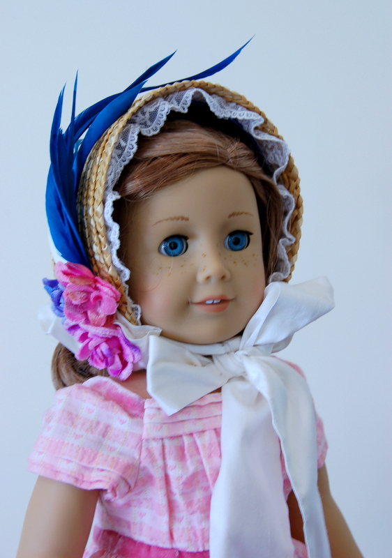 An American Girl doll wears a pink dress and a straw bonnet made from a craft store basket