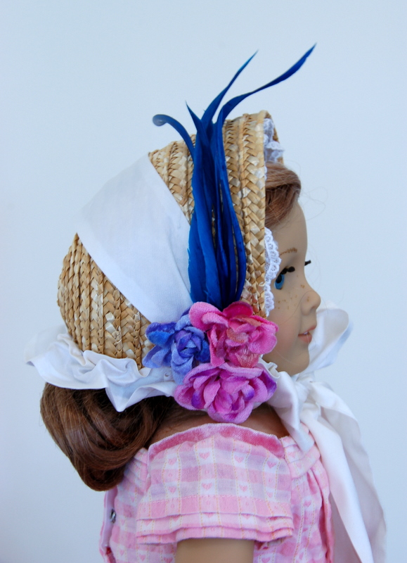 Side View of an American Girl doll wearing a straw bonnet made of a basket from a craft store. The bonnet is decorated with fake flowers and a feather biot