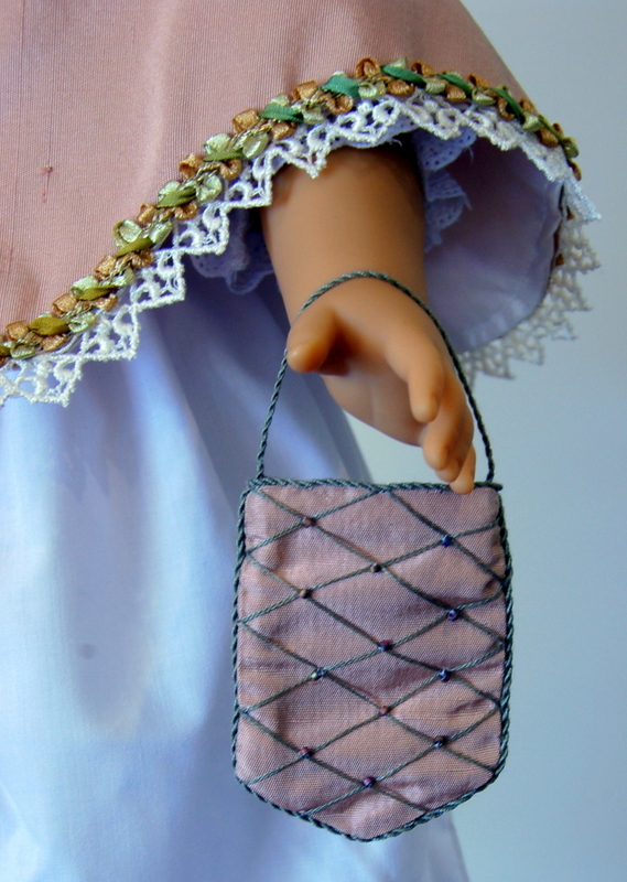 close-up of a small silk doll purse embroidered with beads and green couching