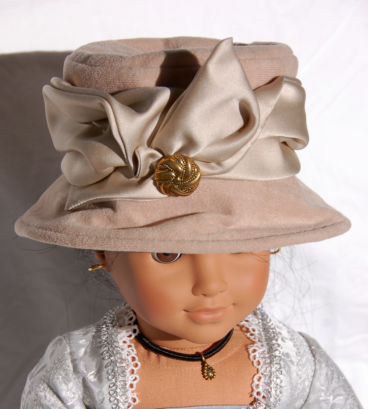 An American Girl Doll wears a brown cloche hat with exuberant satin ribbon trim