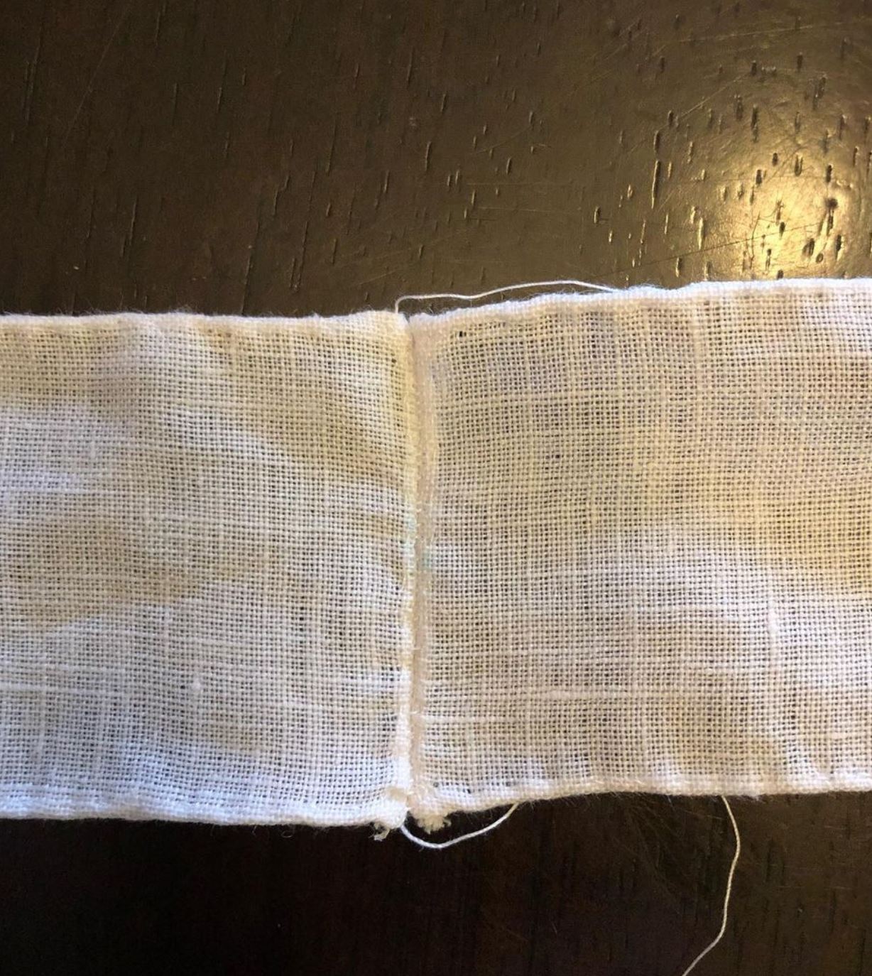 Two strips of linen are butted end to end and whip-stitched together.