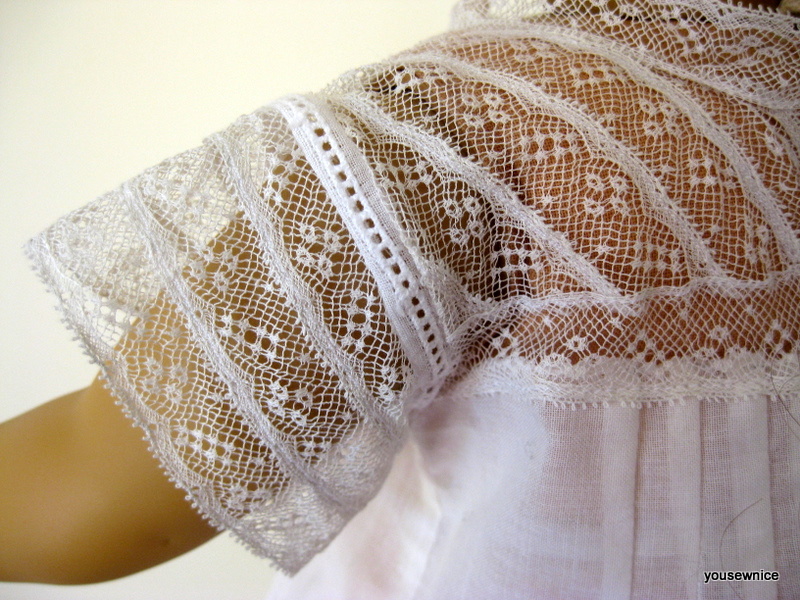 Close-up view of a doll sleeve made of stitched rows of insertion lace
