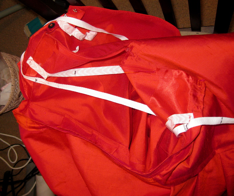 The tapes inside of a fire red silk bustle