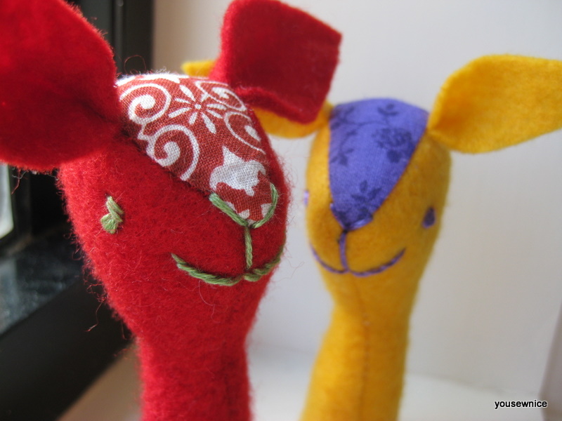 a red and a yellow finger puppet look into the camera