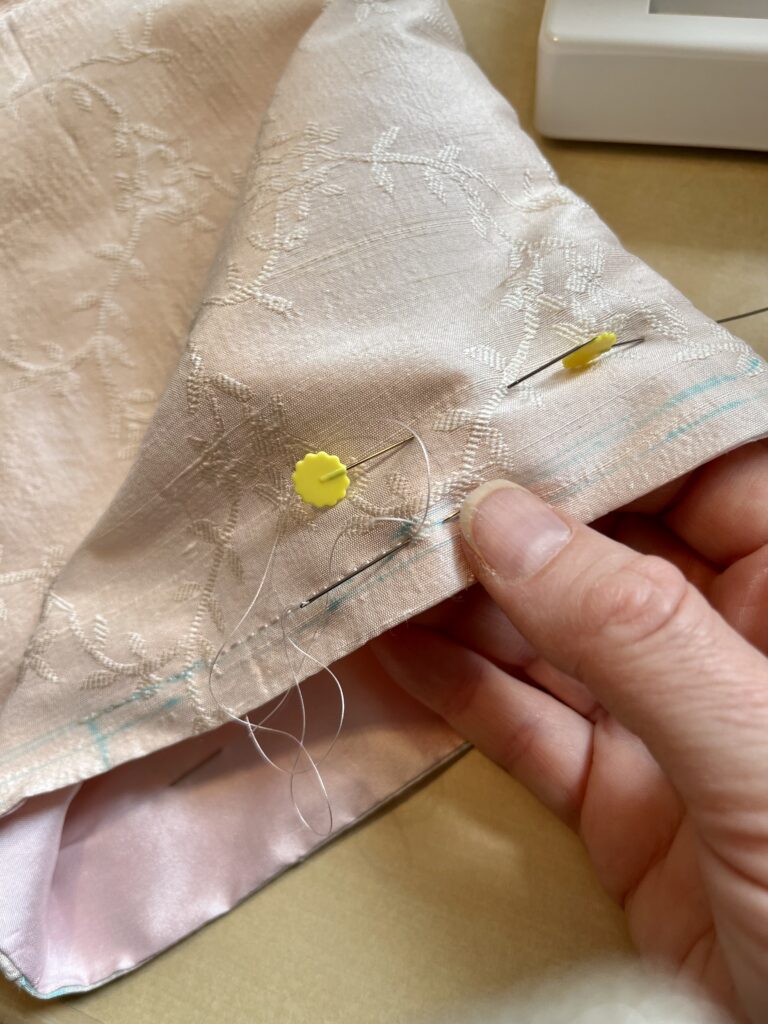 a drawstring channel being backstitiched into pink silk