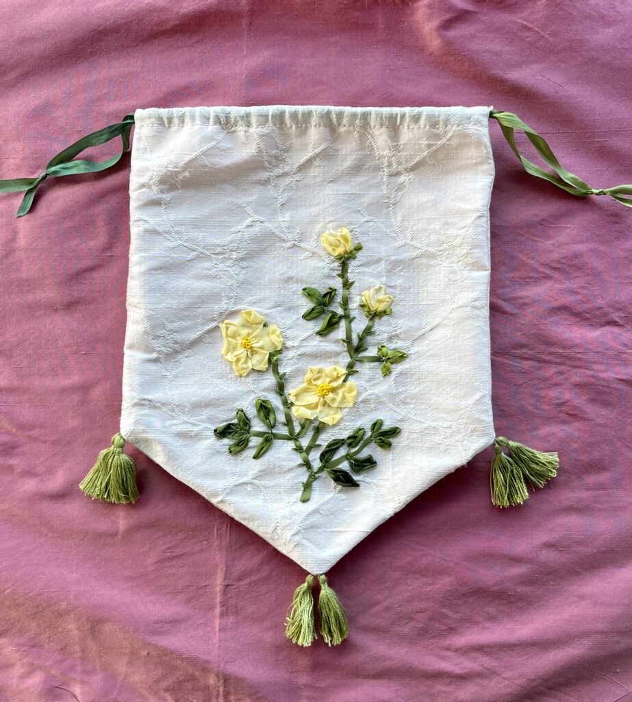 an embroidered regency reticule lies on a piece of pink silk