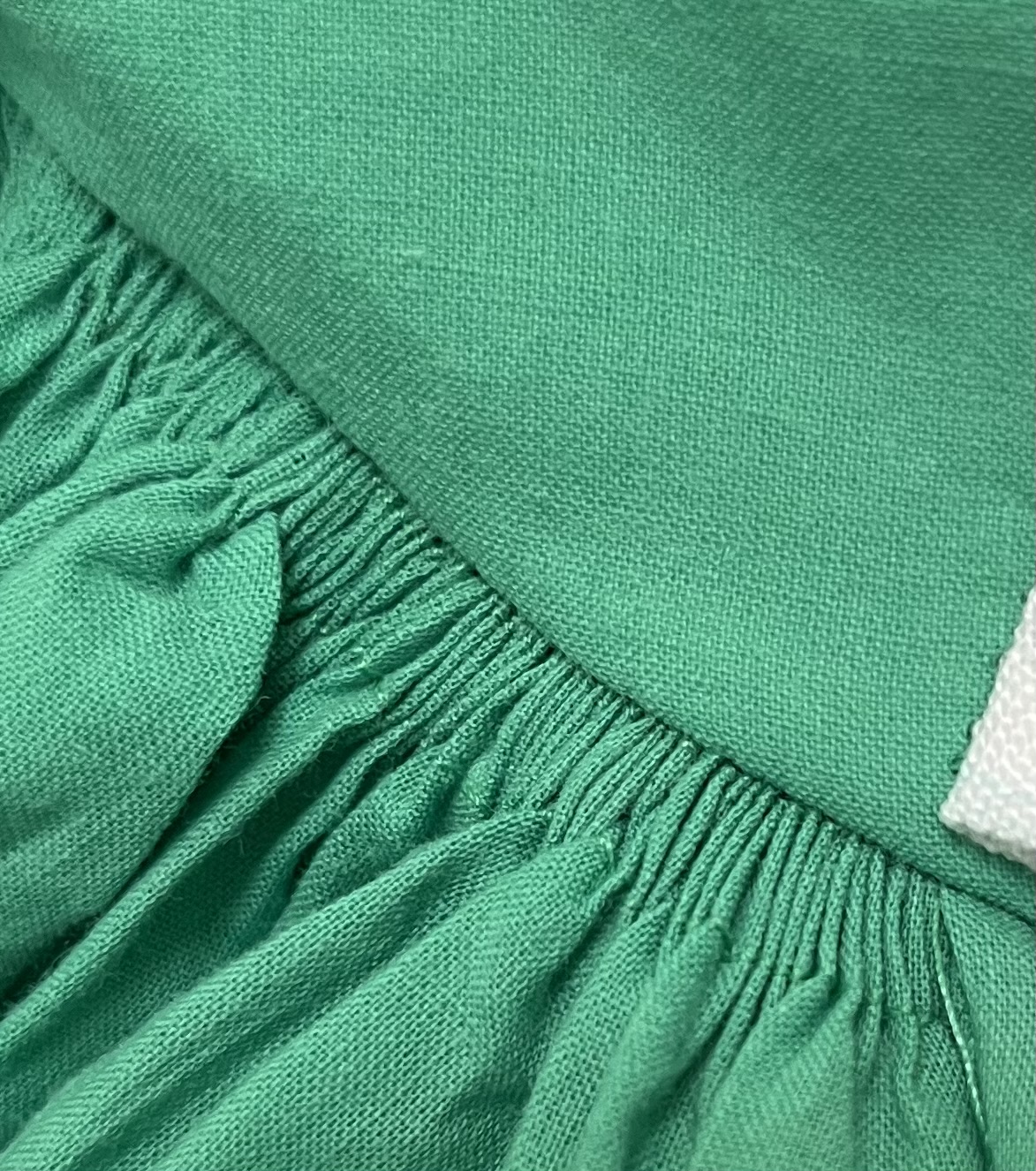A close-up of a green cotton voile panel stitched to another piece of green cotton fabric.