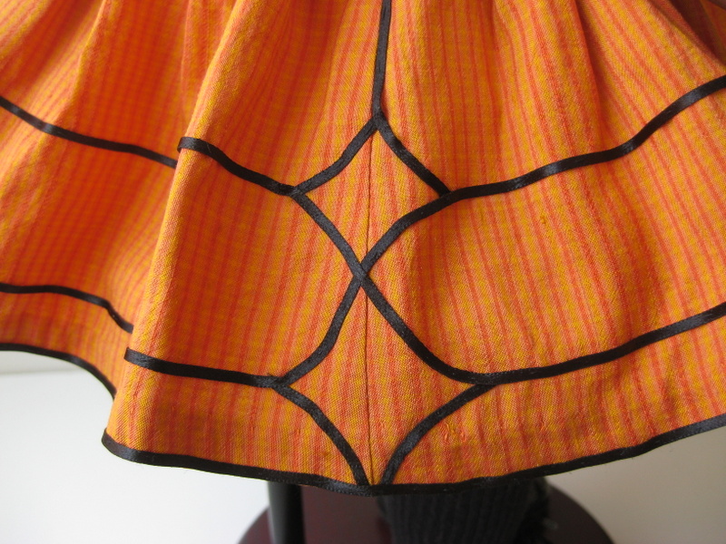 close-up of ribbon trim detail on an orange american girl doll skirt