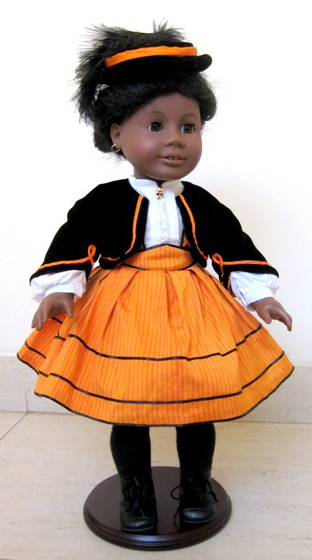 an american girl doll addy wears an orange skirt and a black velvet jacket
