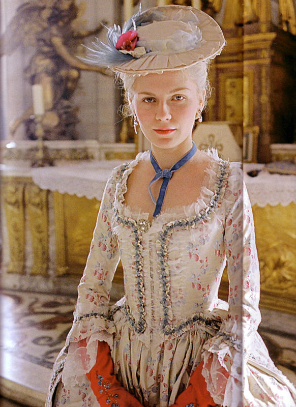kirsten dunst as marie antoinette in a cream floral dress and small hat