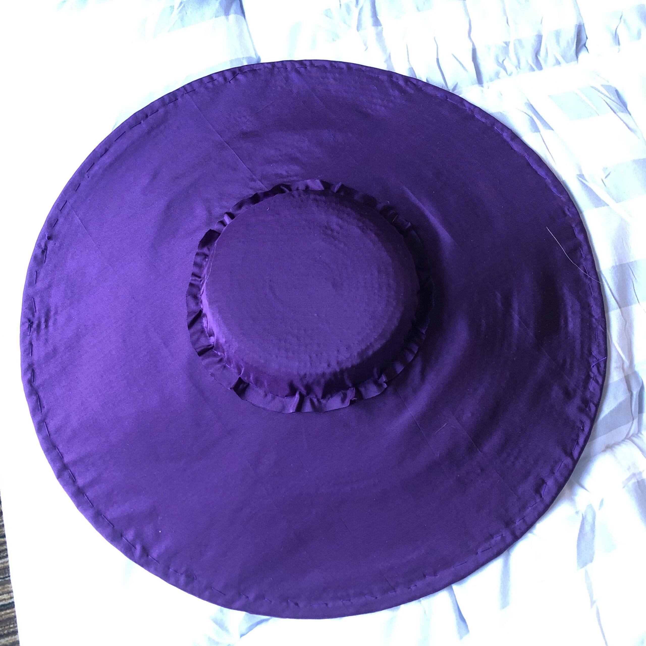A bergere hat in the process of being covered with purple silk taffeta. The crown cover had been attached and cut to fit.