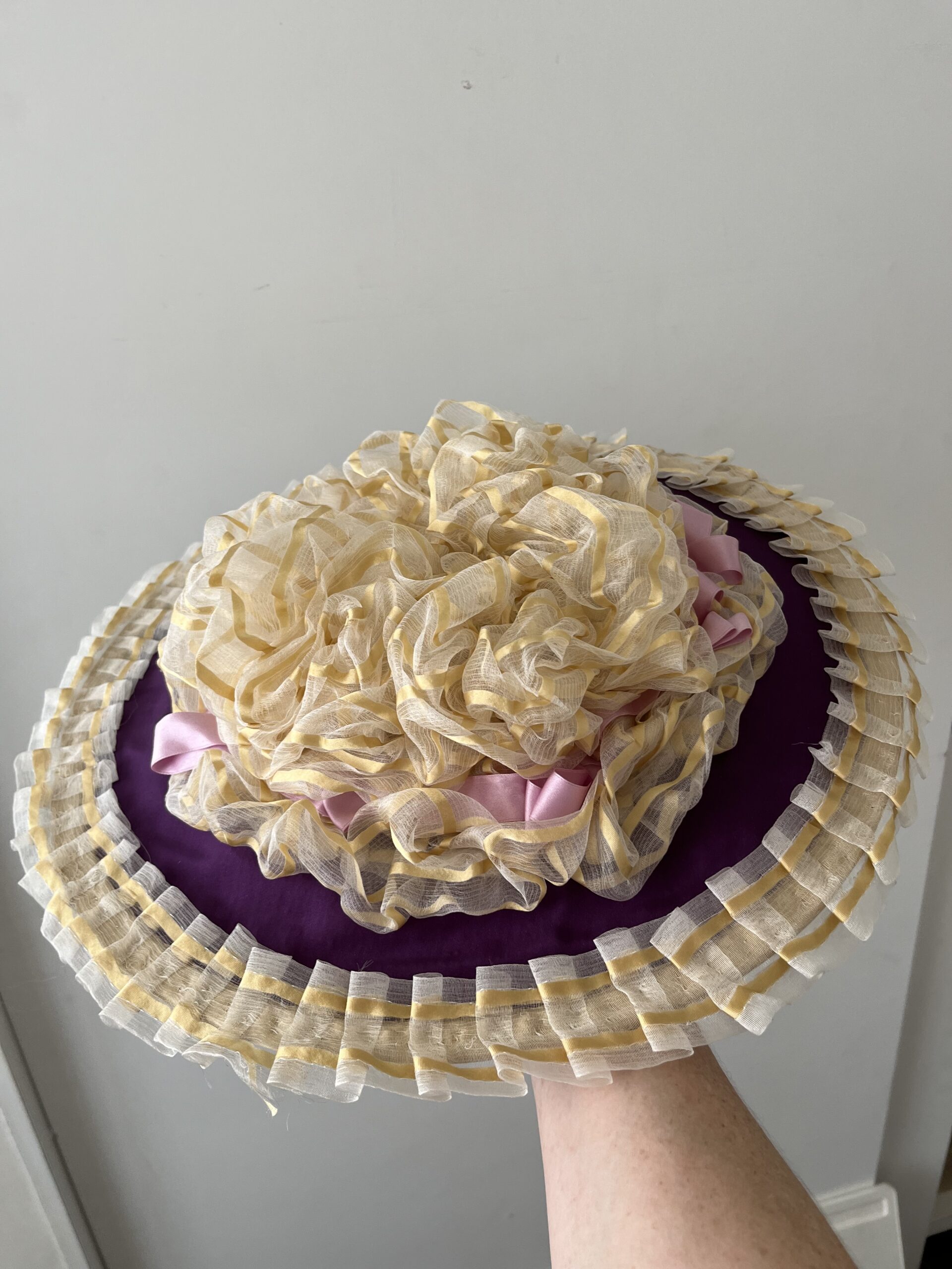 An 18th Century Bergere hat  - the body of the hat is covered in purple silk and the hat is trimmed with gold striped silk gauze and purple ribbons.