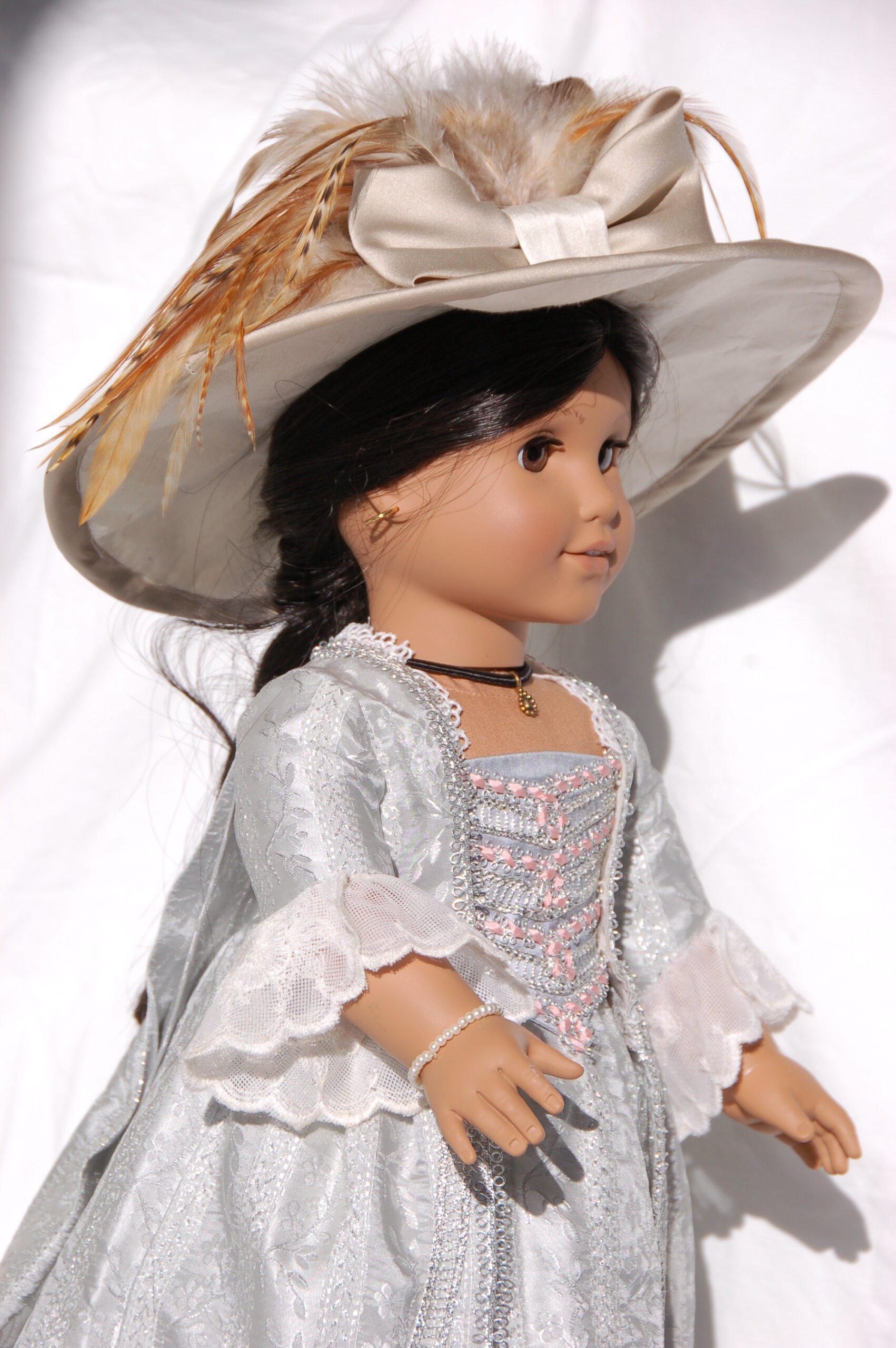 American girl doll wearing a silver robe francaise with a large gainsborough hat