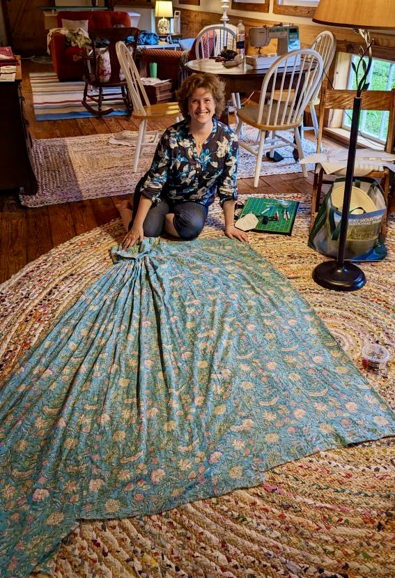 Tabubilgirl sits on the floor next to a spread out 1790s round gown