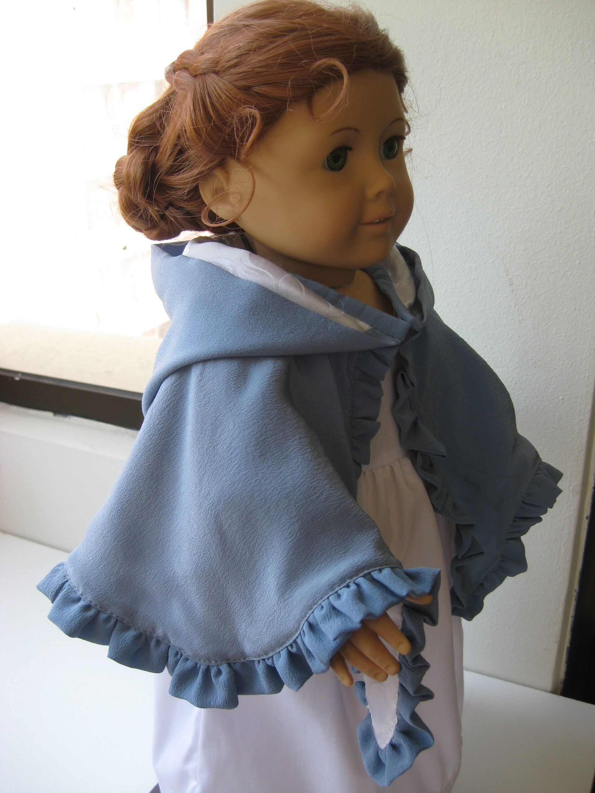 side view of an American Girl doll wearing a blue silk Mantelet