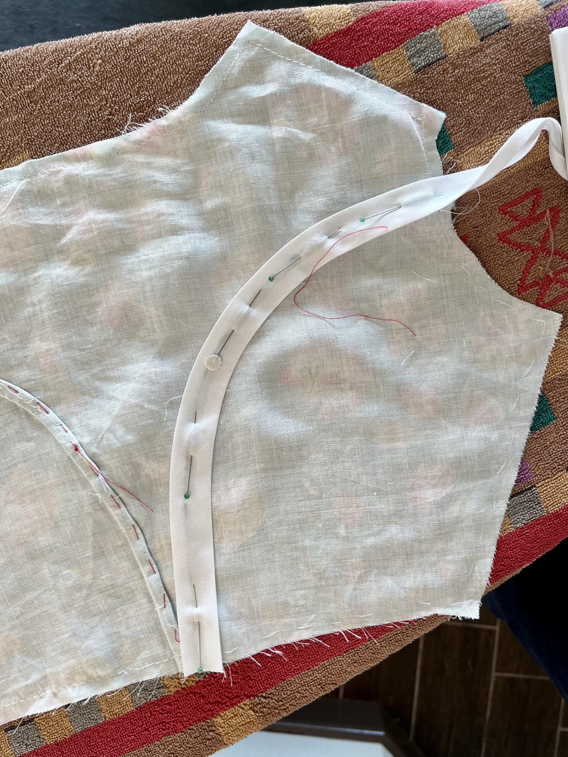 A bodice back with a curve of bias binding pinned along a princess seam