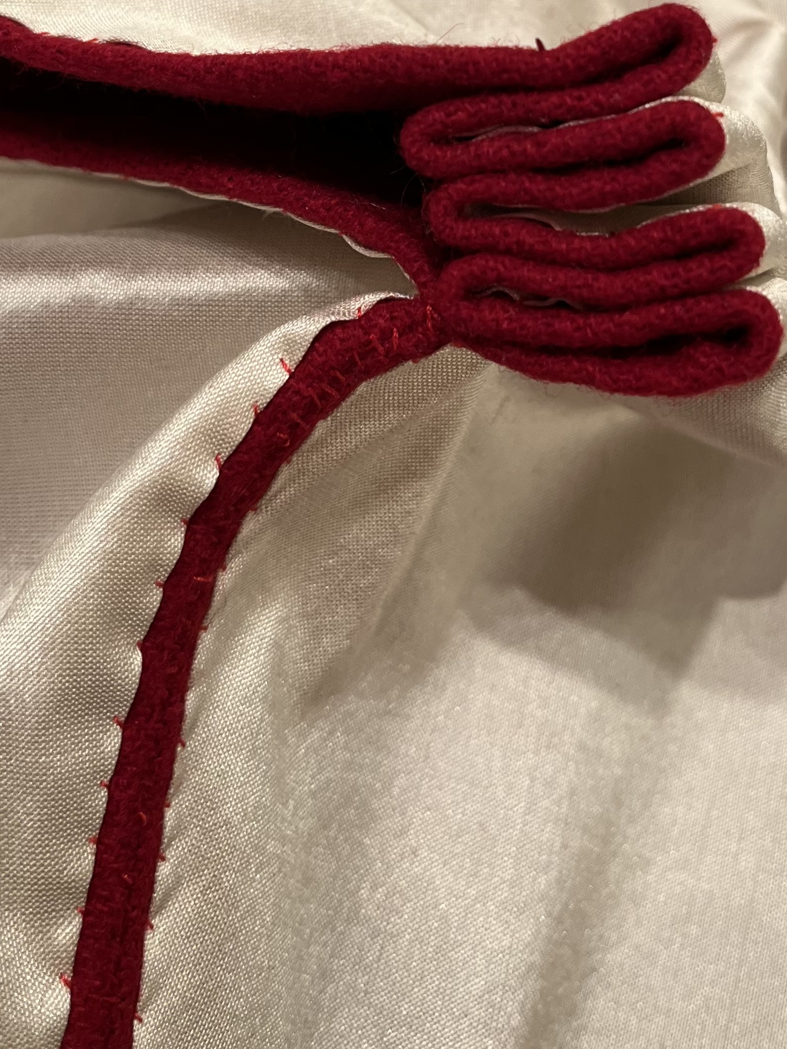 close-up of loose whip stitching attaching a silk lining to a wool hood at the center seam