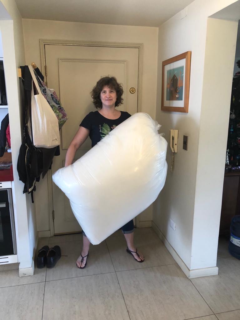 Tabubilgirl holds a giant sack of fiberfill stuffing. It is as tall as she is.