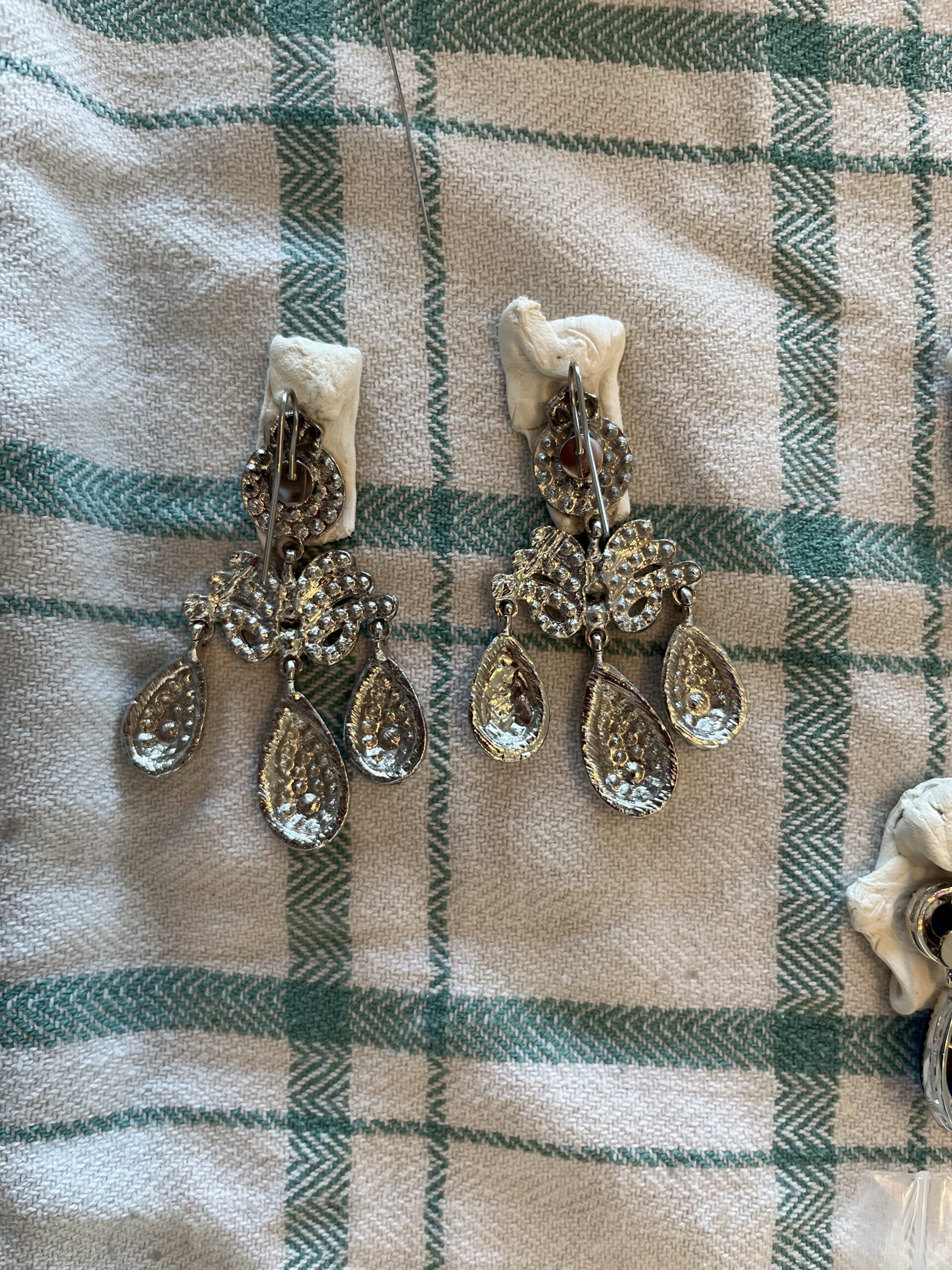 Back View of a pair of 18th Century Girandole Earrings. They lie face down, stuck in wodges of bluetak