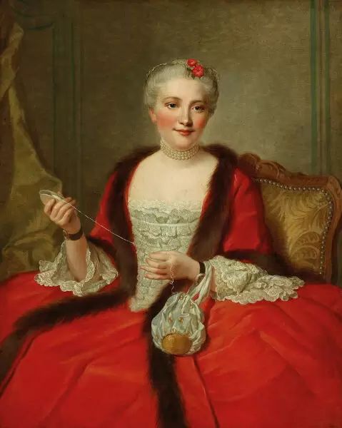 An 18th Century woman wears a long red gown trimmed in dark brown fur. Her white stomacher contrasts elegantly with the red gown.